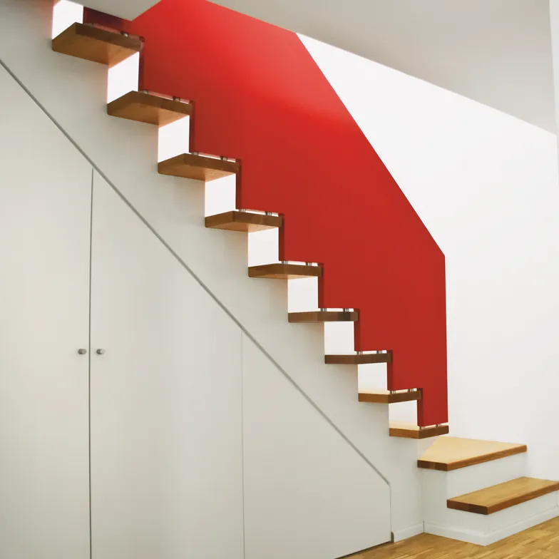 Schranktreppe mit Eichenstufen und rotem Vollholzgeländer. Gebaut von Sonnemann Treppen in Hannover.