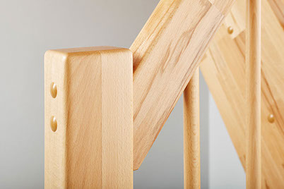 Detailaufnahme eines Treppengeländers mit Holzpfosten aus Buche.
