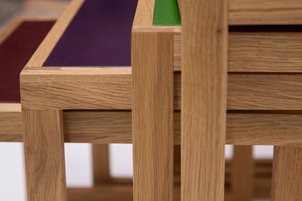 Detailansicht von ineinander geschobenen Satztischen mit farbigen Platten.